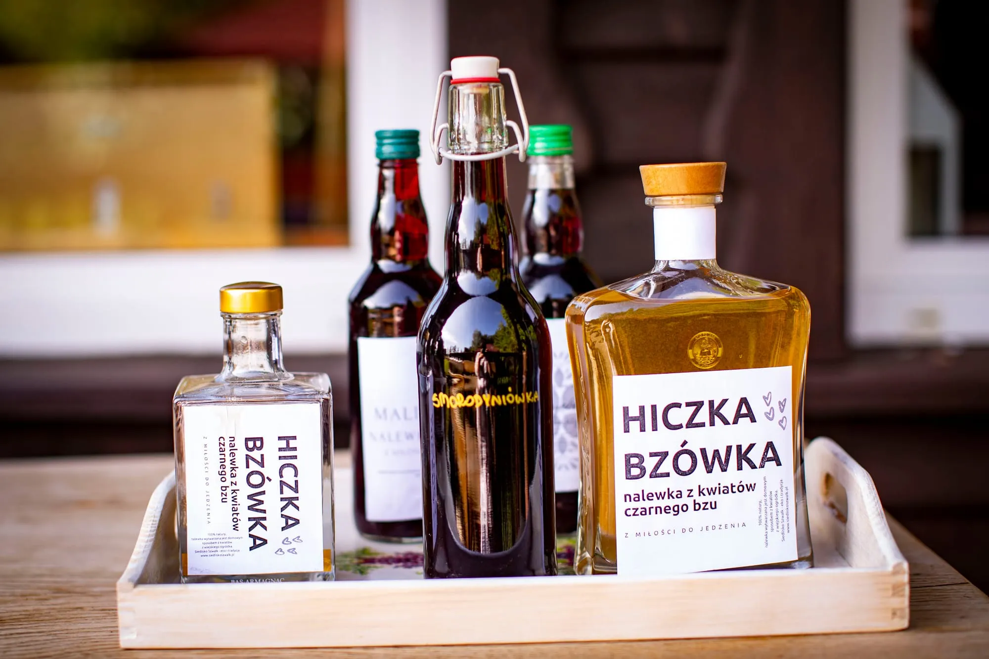 Butelki nalewki „Hiczka Bzówka” na tacy