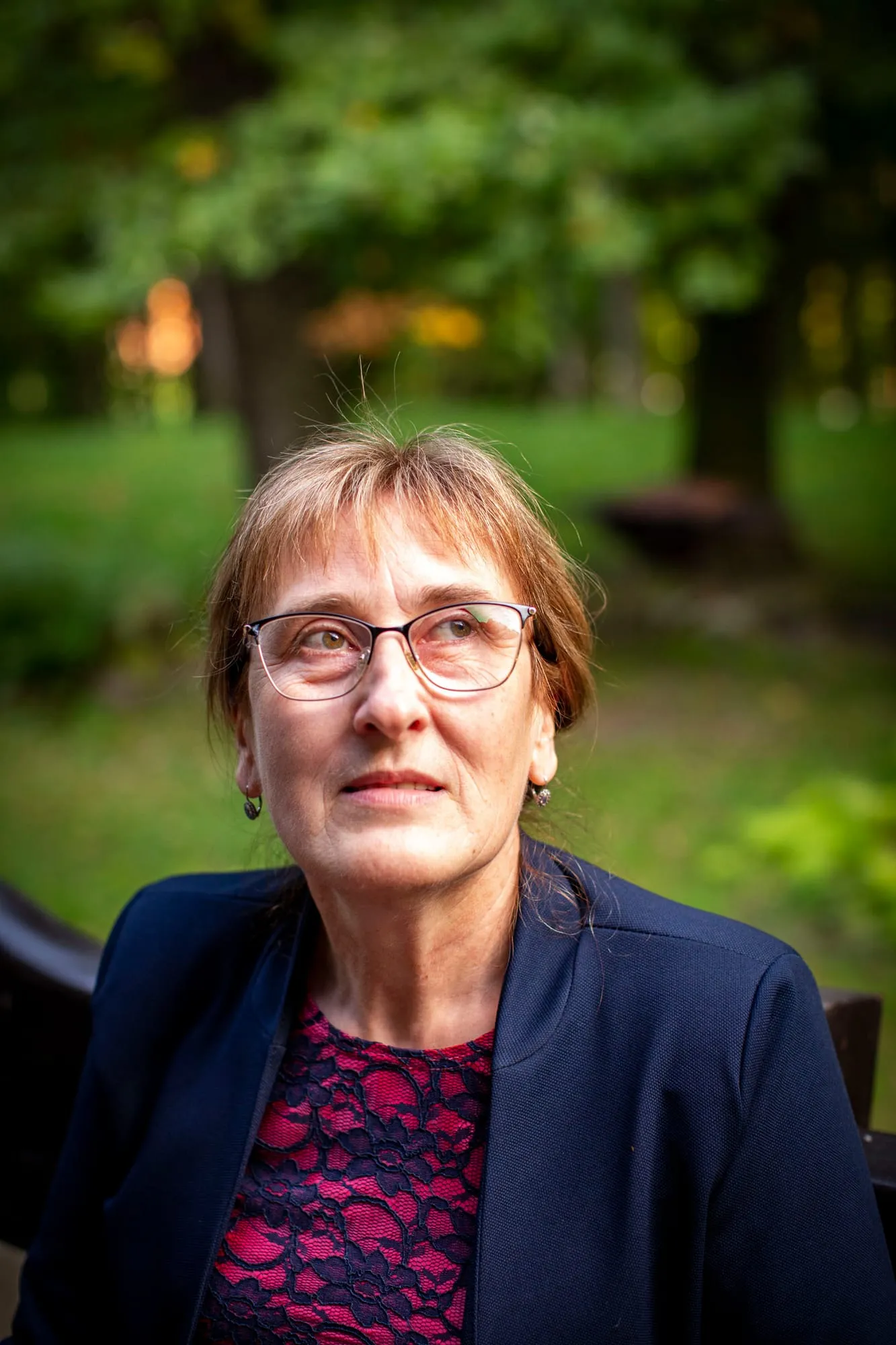 Portret kobiety w okularach i granatowym żakiecie